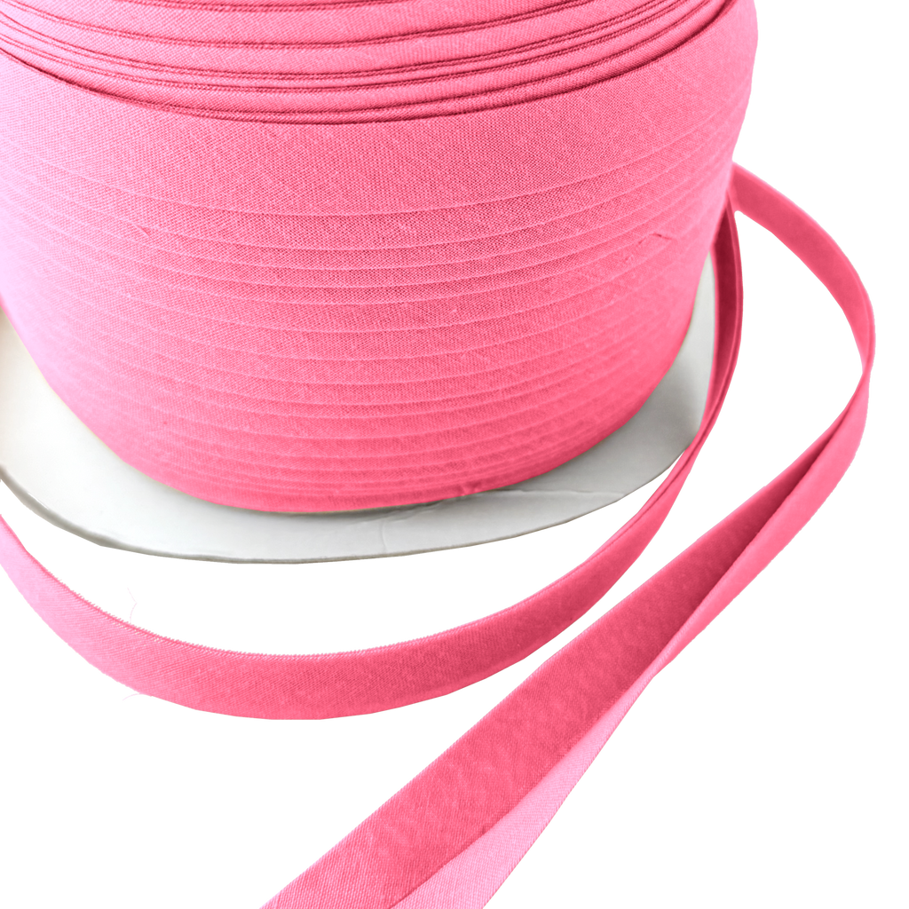 close up of the bubblegum 1/2" double fold bias tape on a spool from Heit's Wholesale bulk sewing supply company