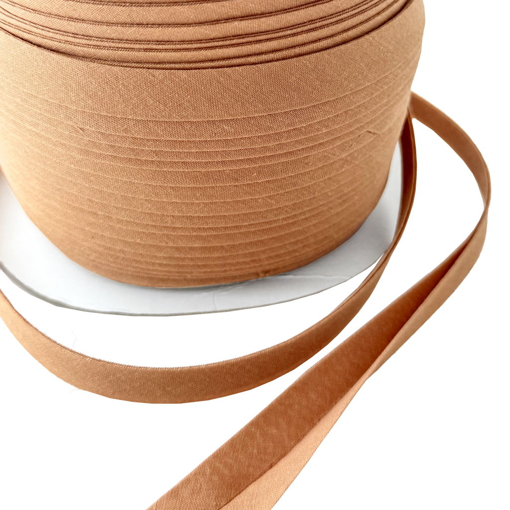 close up of the camel brown 1/2" double fold bias tape on a spool from Heit's Wholesale bulk sewing supply company