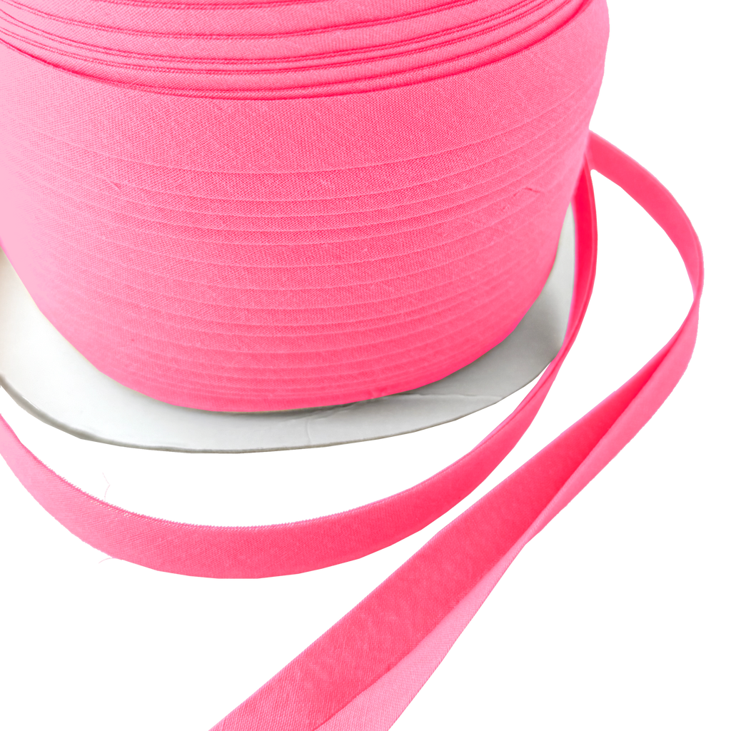 close up of the candy pink 1/2" double fold bias tape on a spool from Heit's Wholesale bulk sewing supply company