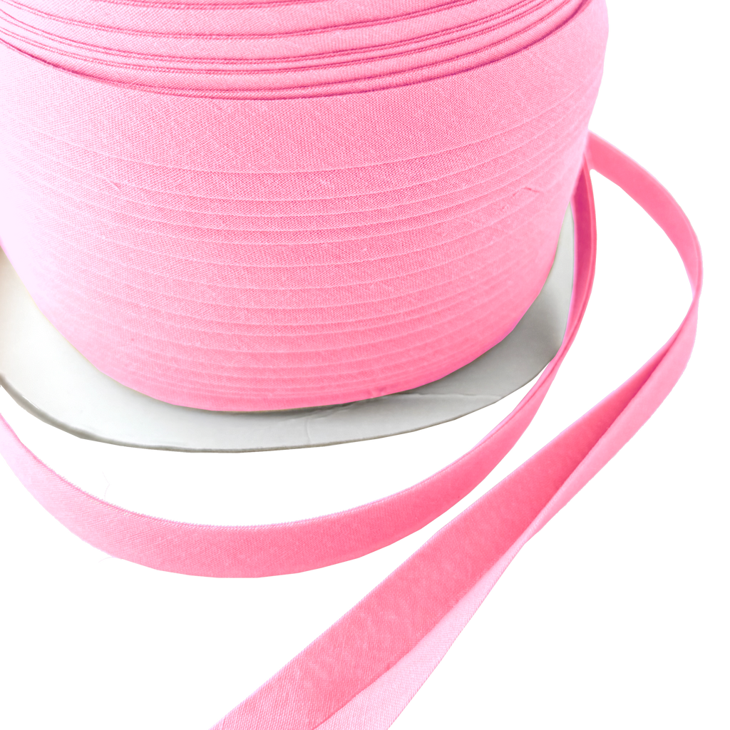 close up of the cotton candy pink 1/2" double fold bias tape on a spool from Heit's Wholesale bulk sewing supply company