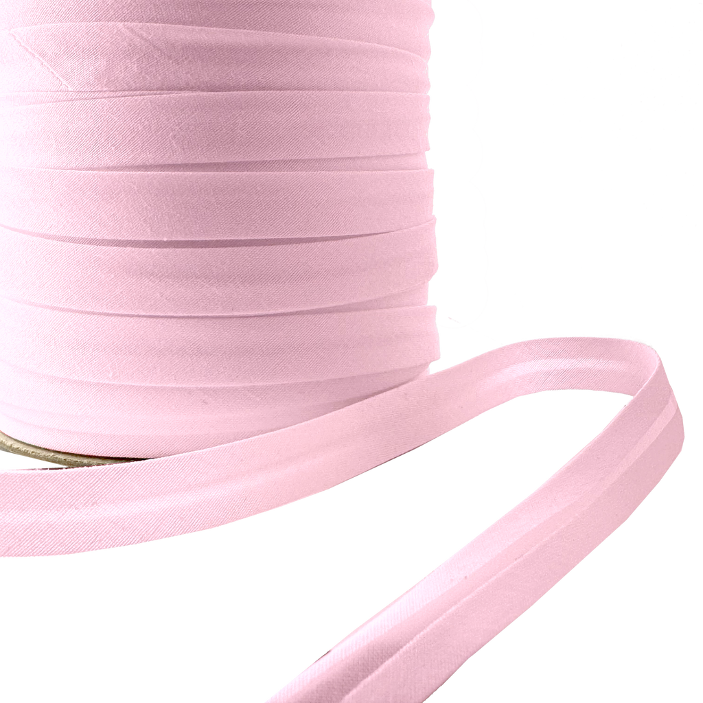 close up of the petal pink 1/2" single fold bias tape on a spool from Heit's Wholesale bulk sewing supply company