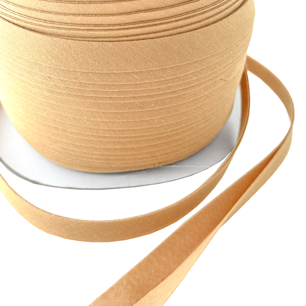 close up of the wheat 1/2" double fold bias tape on a spool from Heit's Wholesale bulk sewing supply company