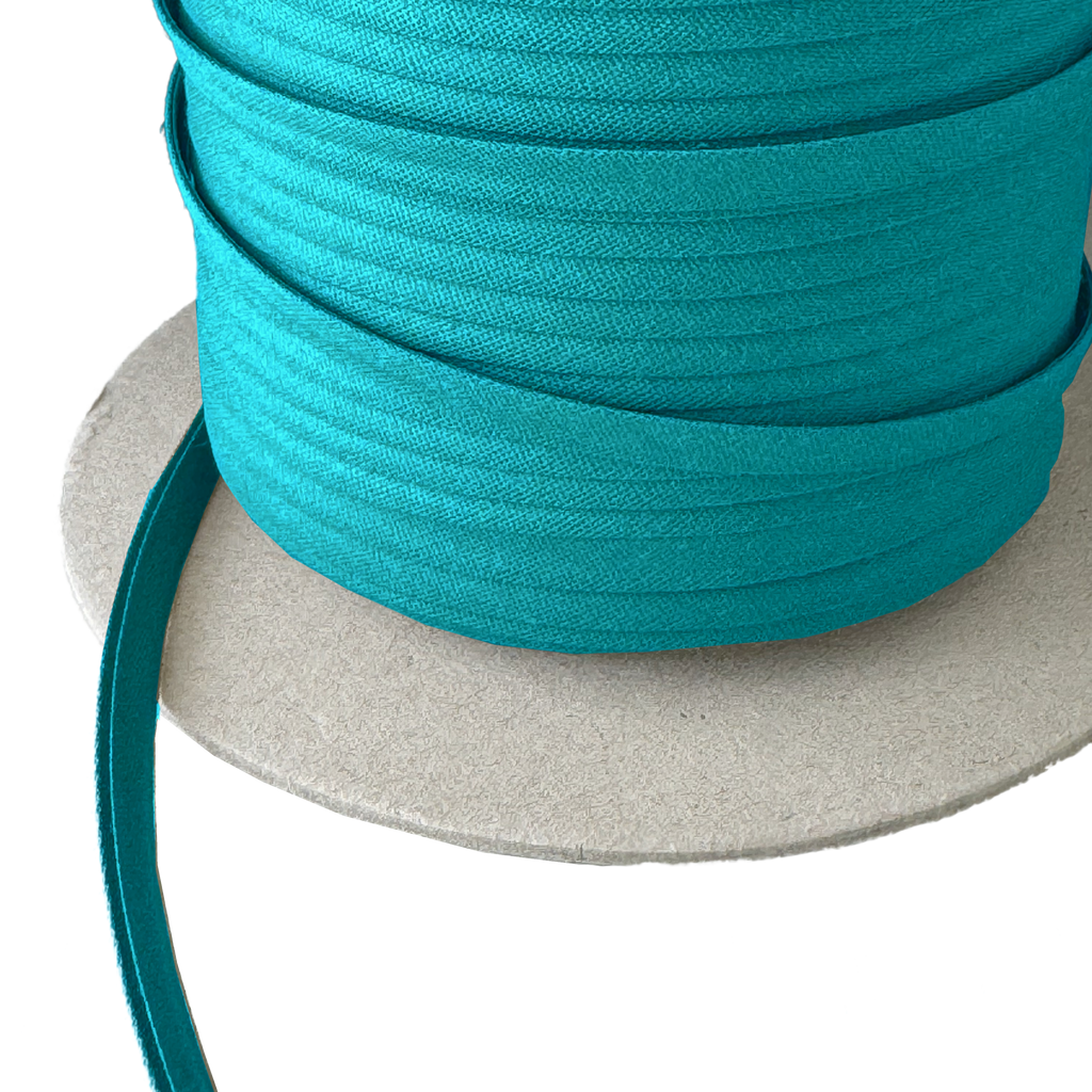 close up of the aquarius blue 1/4" double fold bias tape on a spool from Heit's Wholesale bulk sewing supply company