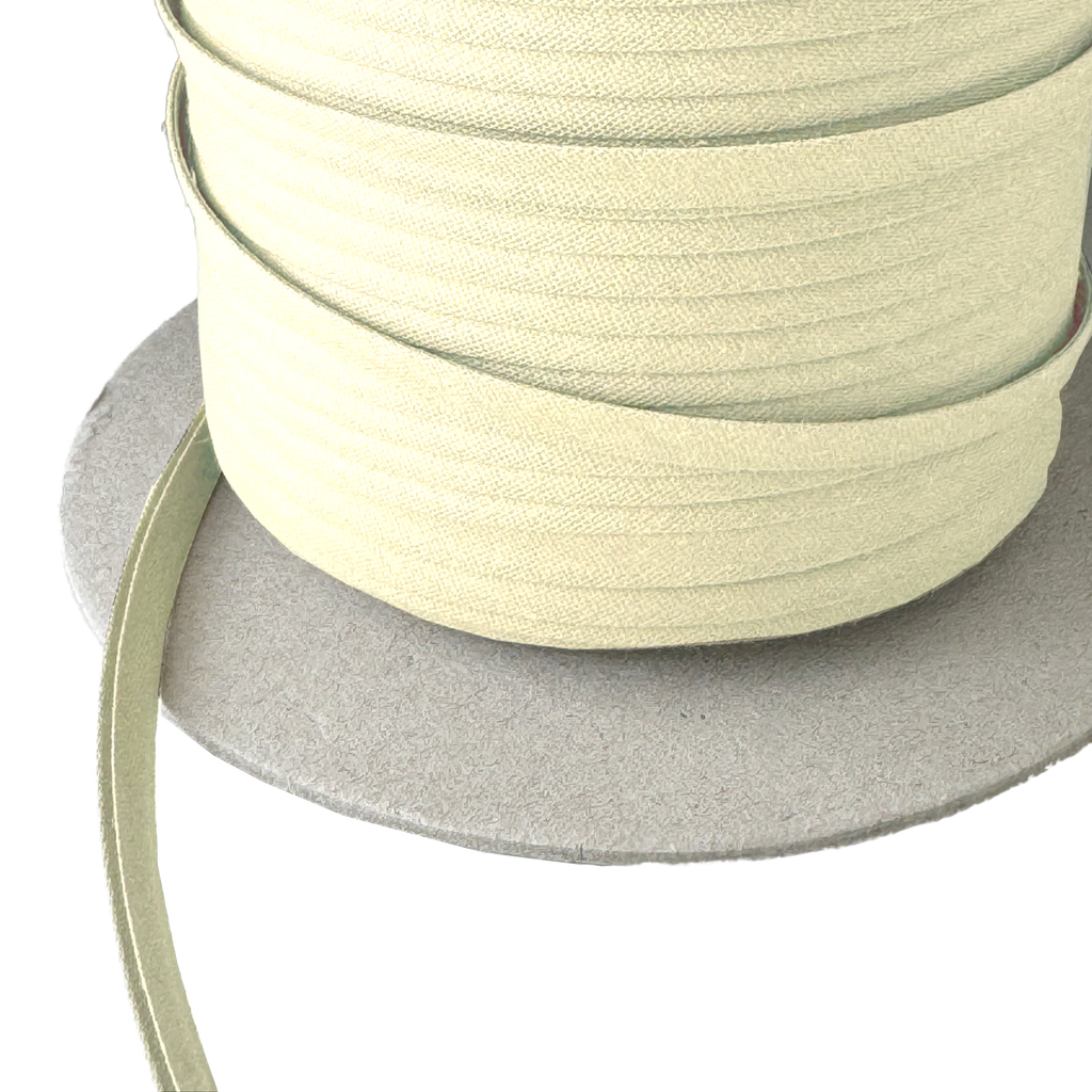 close up photo of the bamboo 1/4" double fold bias tape on a spool from Heit's Wholesale bulk sewing supply company
