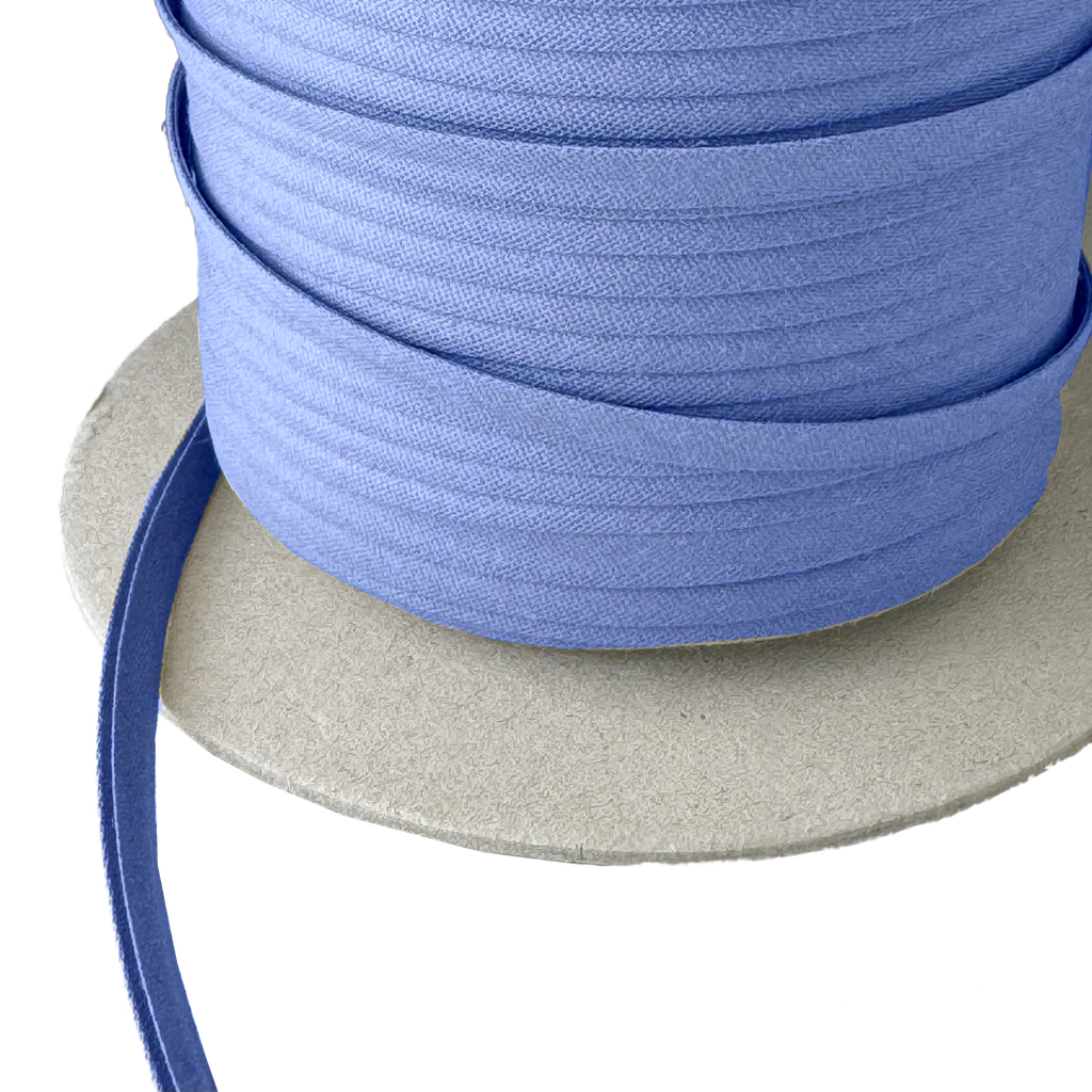close up of the blue crest 1/4" double fold bias tape on a spool from Heit's Wholesale bulk sewing supply company