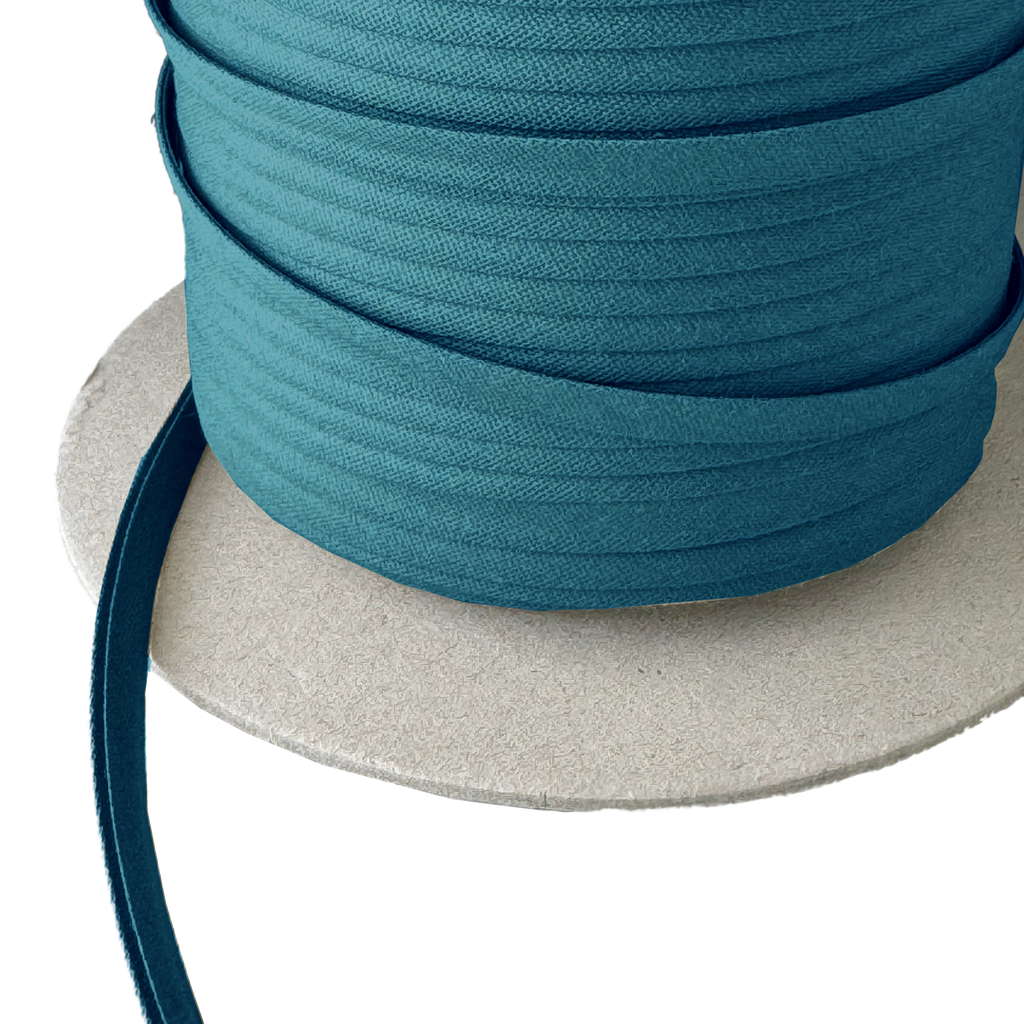 close up of the bottle green 1/4" double fold bias tape on a spool from Heit's Wholesale bulk sewing supply company