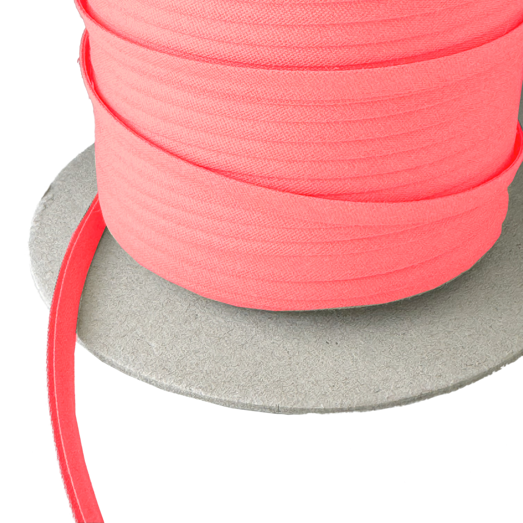 close up of the brandy pink 1/4" double fold bias tape on a spool from Heit's Wholesale bulk sewing supply company