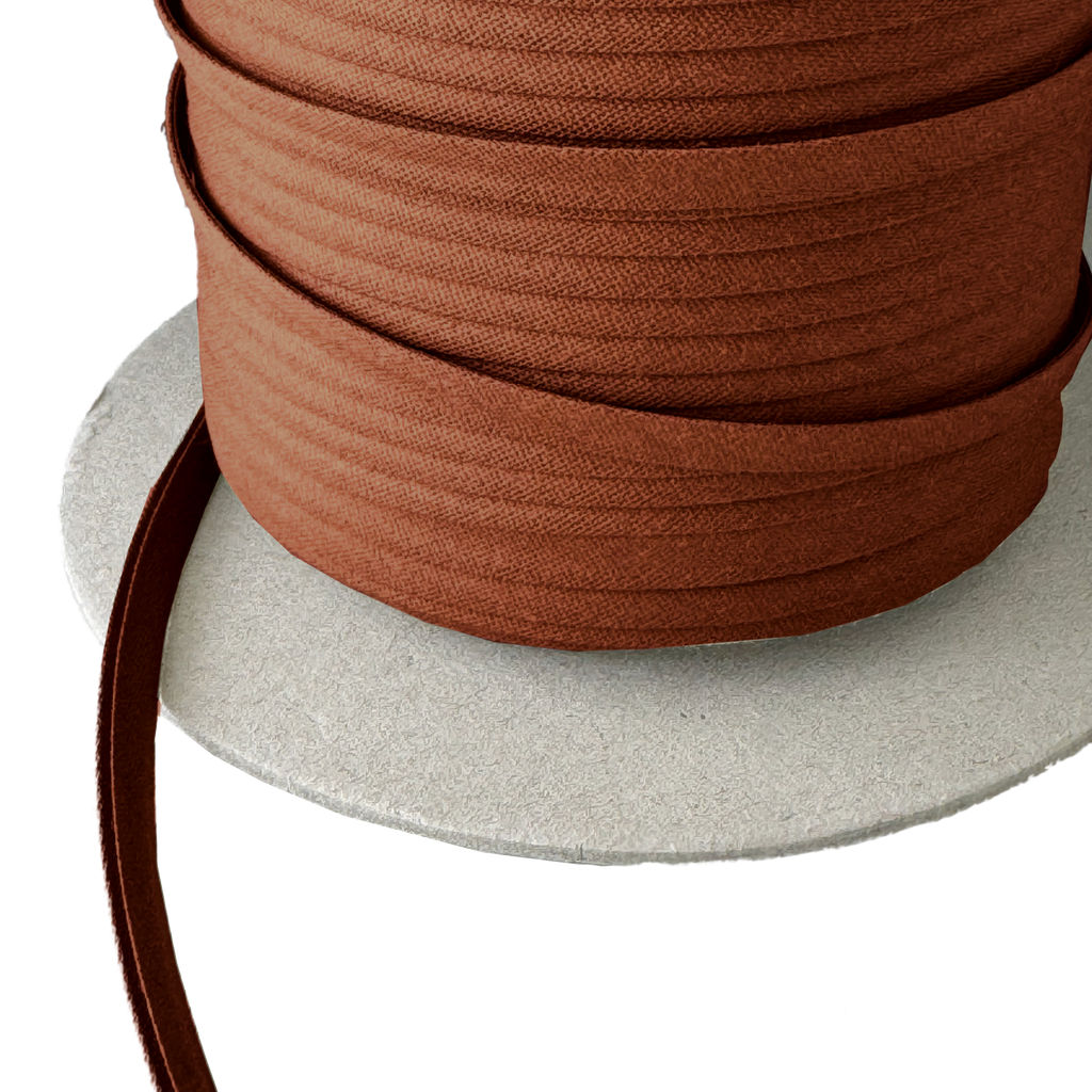 close up of the brown 1/4" double fold bias tape on a spool from Heit's Wholesale bulk sewing supply company
