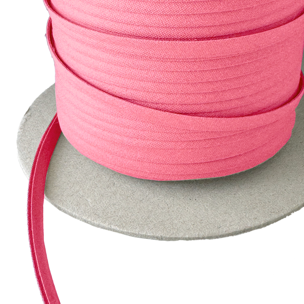 closer view of the bubblegum 1/4" double fold bias tape on a spool from Heit's Wholesale bulk sewing supply company