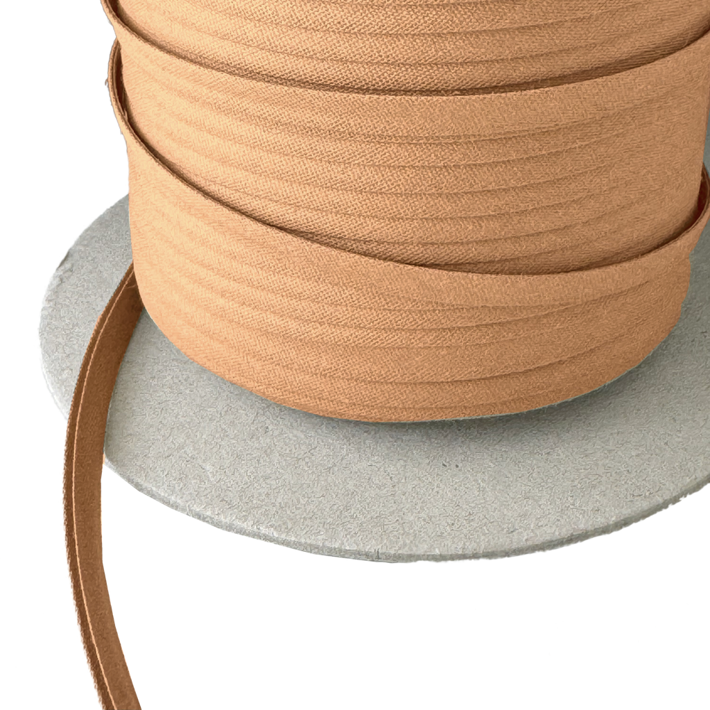 close up of the camel brown 1/4" double fold bias tape on a spool from Heit's Wholesale bulk sewing supply company