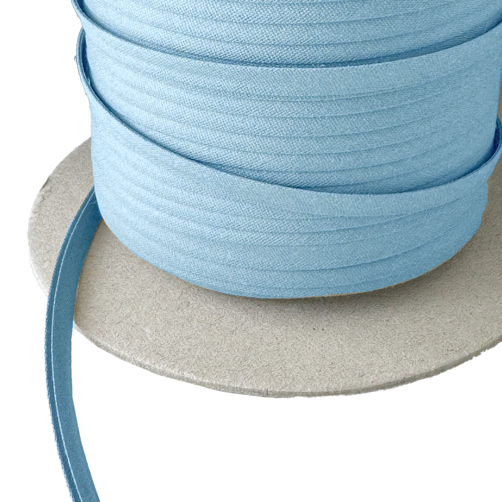 close up of the gay blue 1/4" double fold bias tape on a spool from Heit's Wholesale bulk sewing supply company