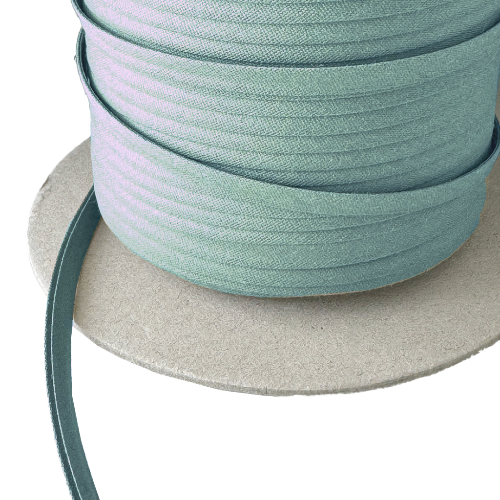 close up of the josie green 1/4" double fold bias tape on a spool from Heit's Wholesale bulk sewing supply company