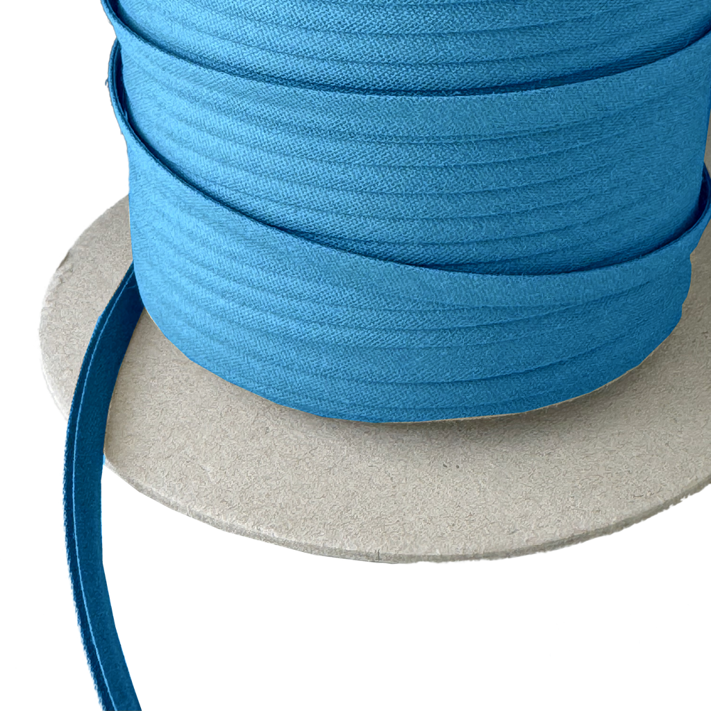 close up of the miami blue 1/4" double fold bias tape on a spool from Heit's Wholesale bulk sewing supply company