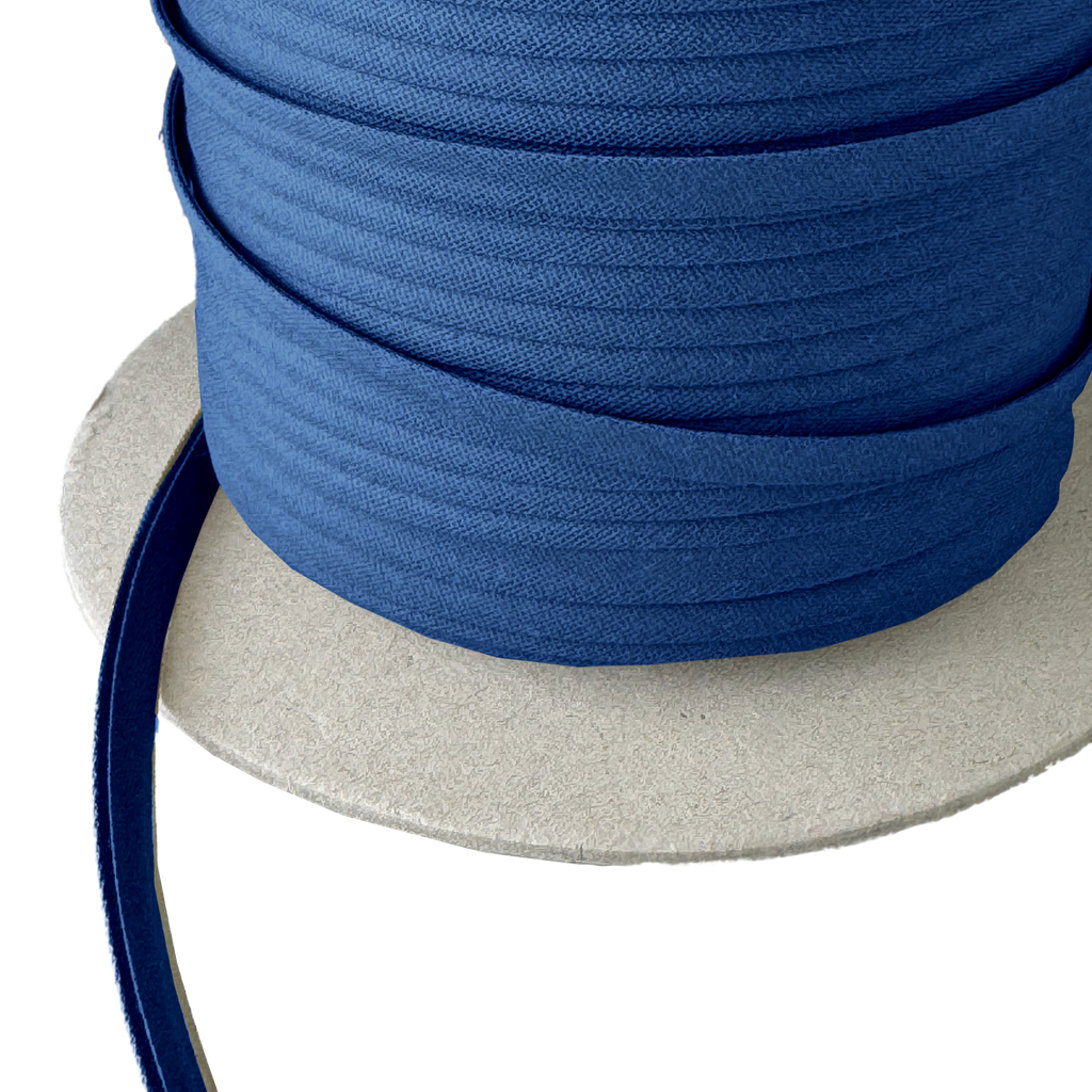 close up of the royal blue 1/4" double fold bias tape on a spool from Heit's Wholesale bulk sewing supply company