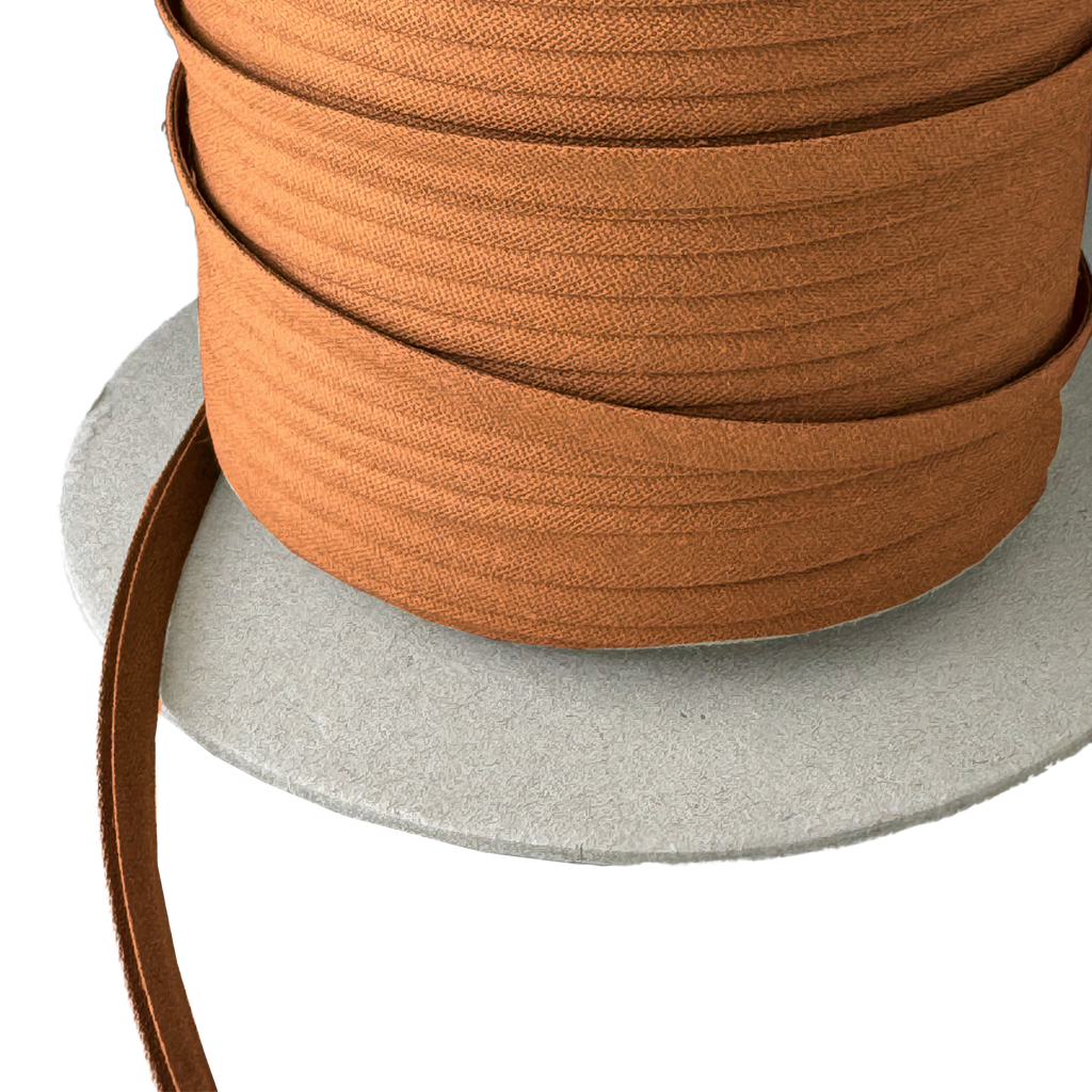 close up of the sandlewood brown 1/4" double fold bias tape on a spool from Heit's Wholesale bulk sewing supply company