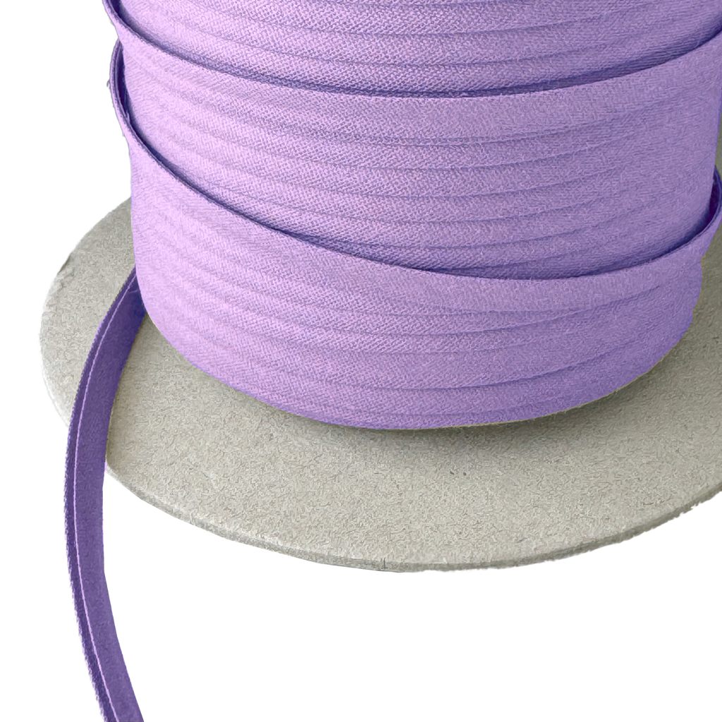 close up of the violet 1/4" double fold bias tape on a spool from Heit's Wholesale bulk sewing supply company