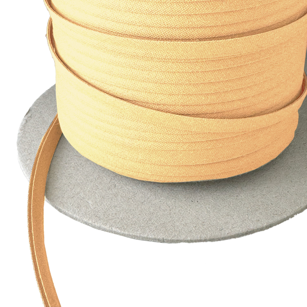 close up of the wheat 1/4" double fold bias tape on a spool from Heit's Wholesale bulk sewing supply company