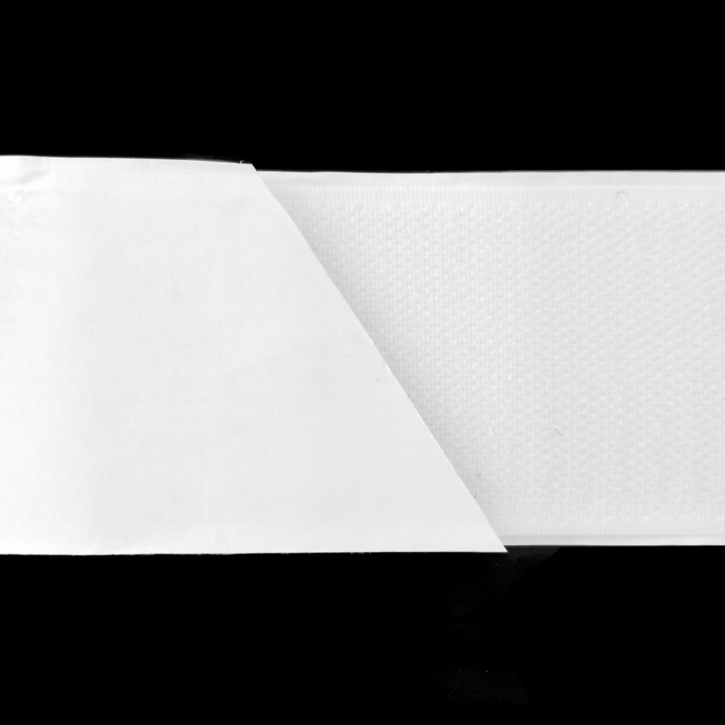 close up of the white 2" self-adhesive Velcro on a spool from Heit's Wholesale bulk sewing supply company