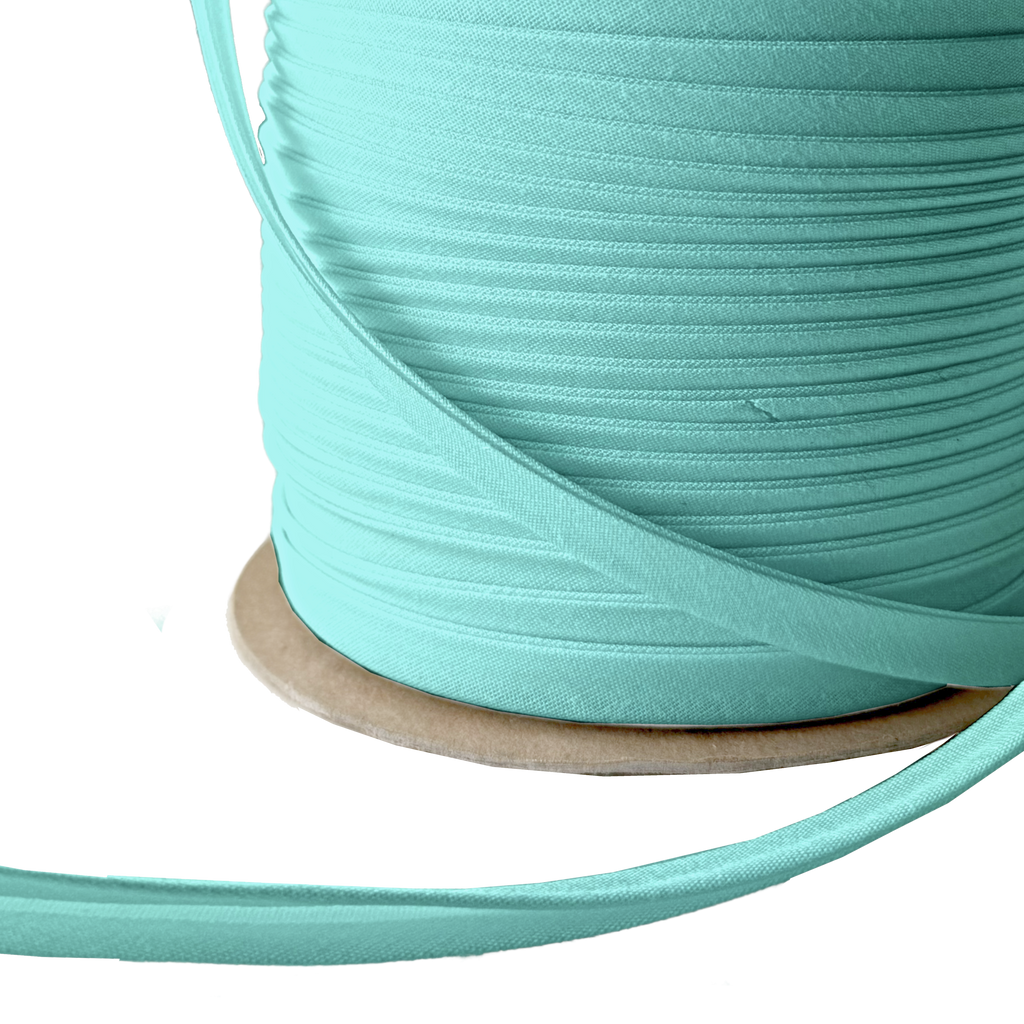 close up of the aqua 3/8" double fold bias tape on a spool from Heit's Wholesale bulk sewing supply company