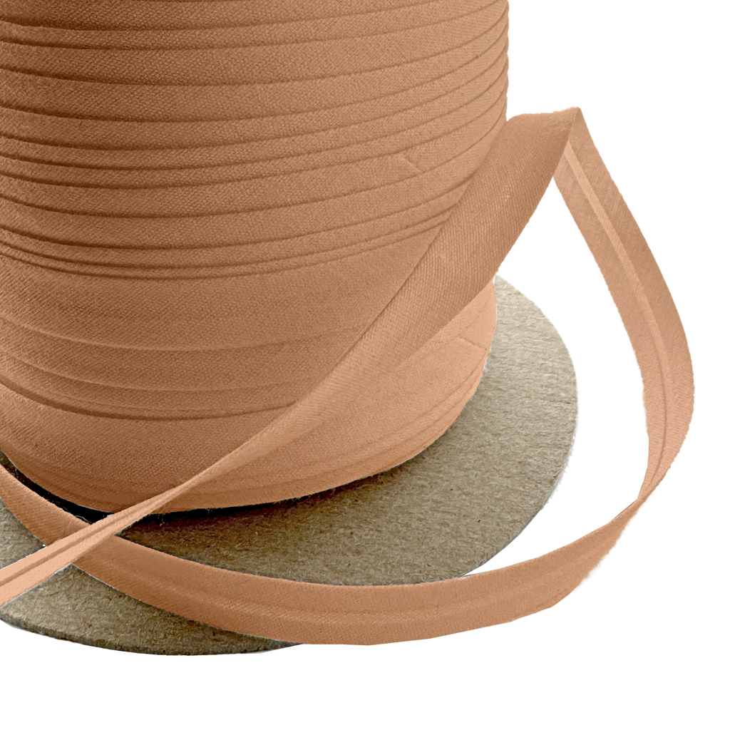 close up of the camel 3/8" single fold bias tape on a spool from Heit's Wholesale bulk sewing supply company