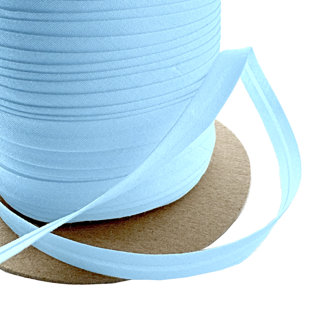 close up of the cloud blue 3/8" single fold bias tape on a spool from Heit's Wholesale bulk sewing supply company