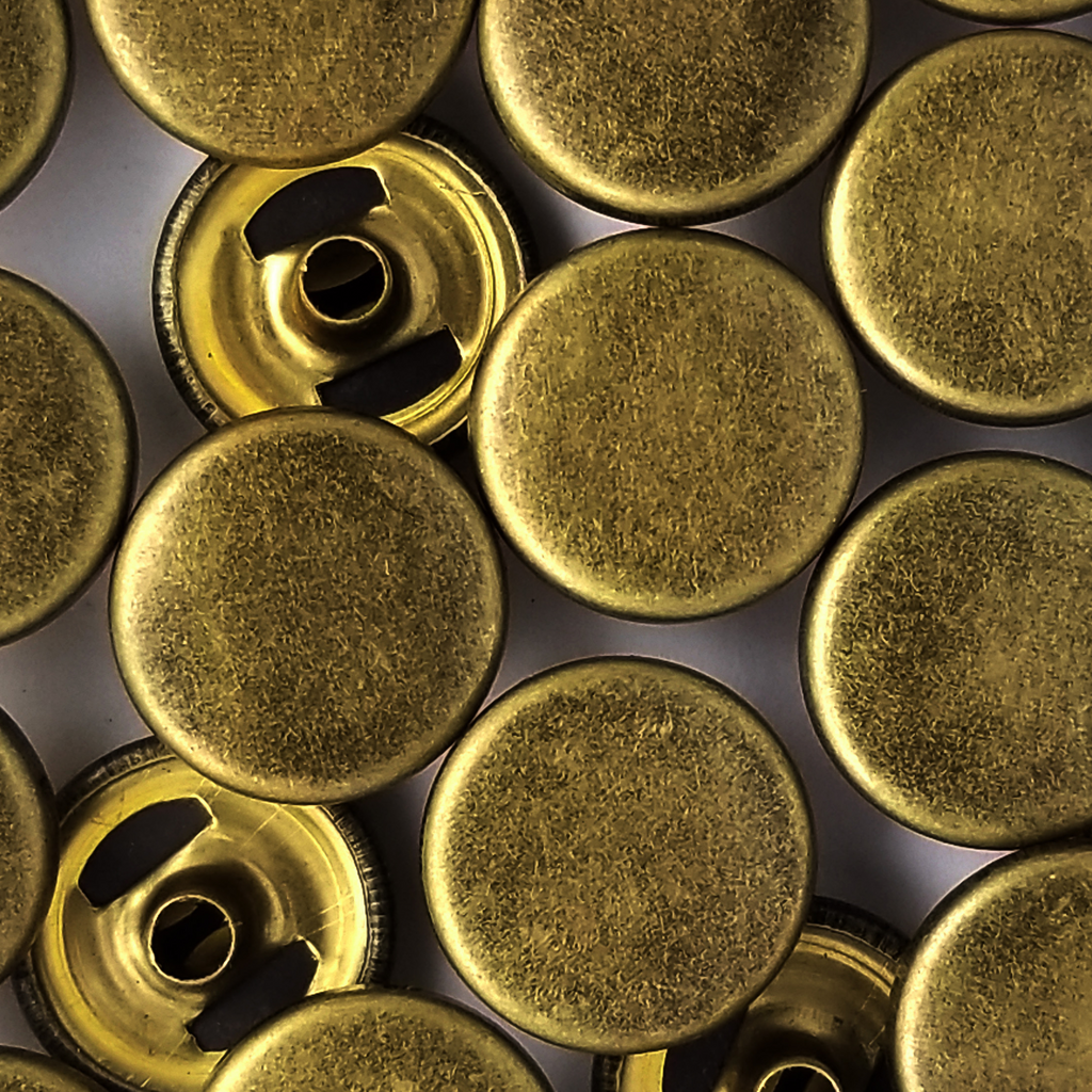 group of the antique brass size 24 spring snaps for lightweight jackets from Heit's Wholesale bulk sewing supply company