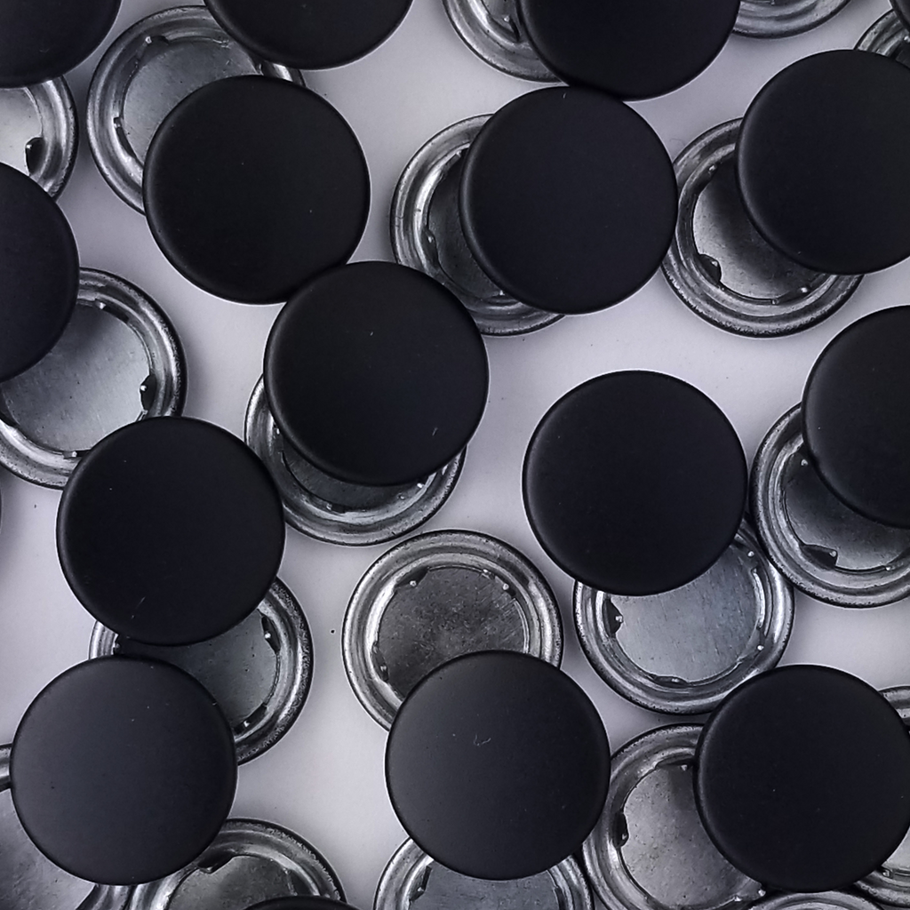 group of the black size 14 capped snaps with a matte finish from Heit's Wholesale bulk sewing supply company