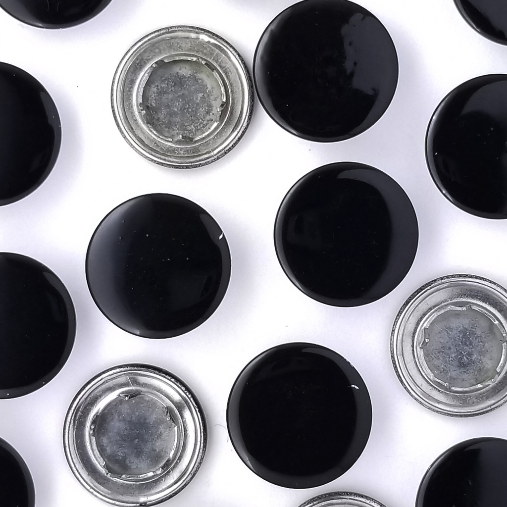 group of the shiny black size 20 capped gripper snaps from Heit's Wholesale bulk sewing supply company