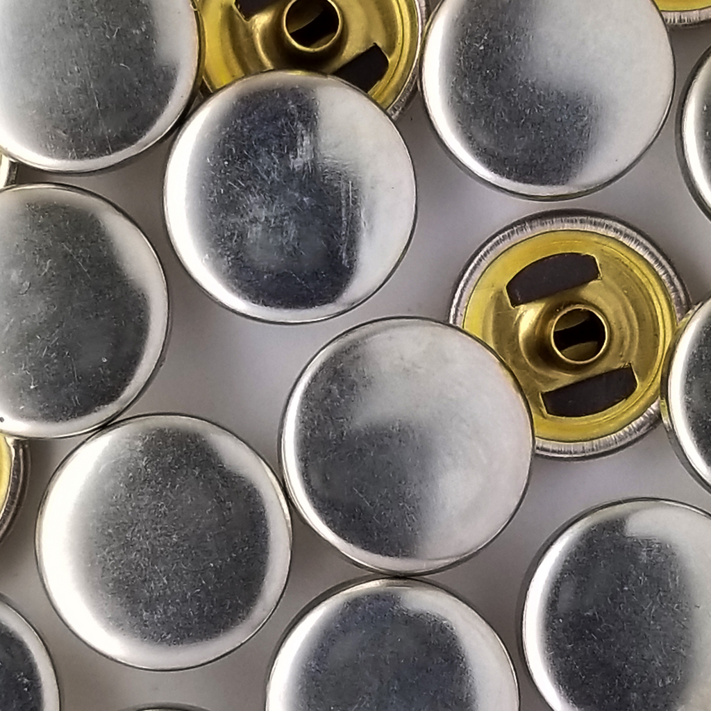 group of the shiny silver size 24 spring snaps for lightweight jackets from Heit's Wholesale bulk sewing supply company