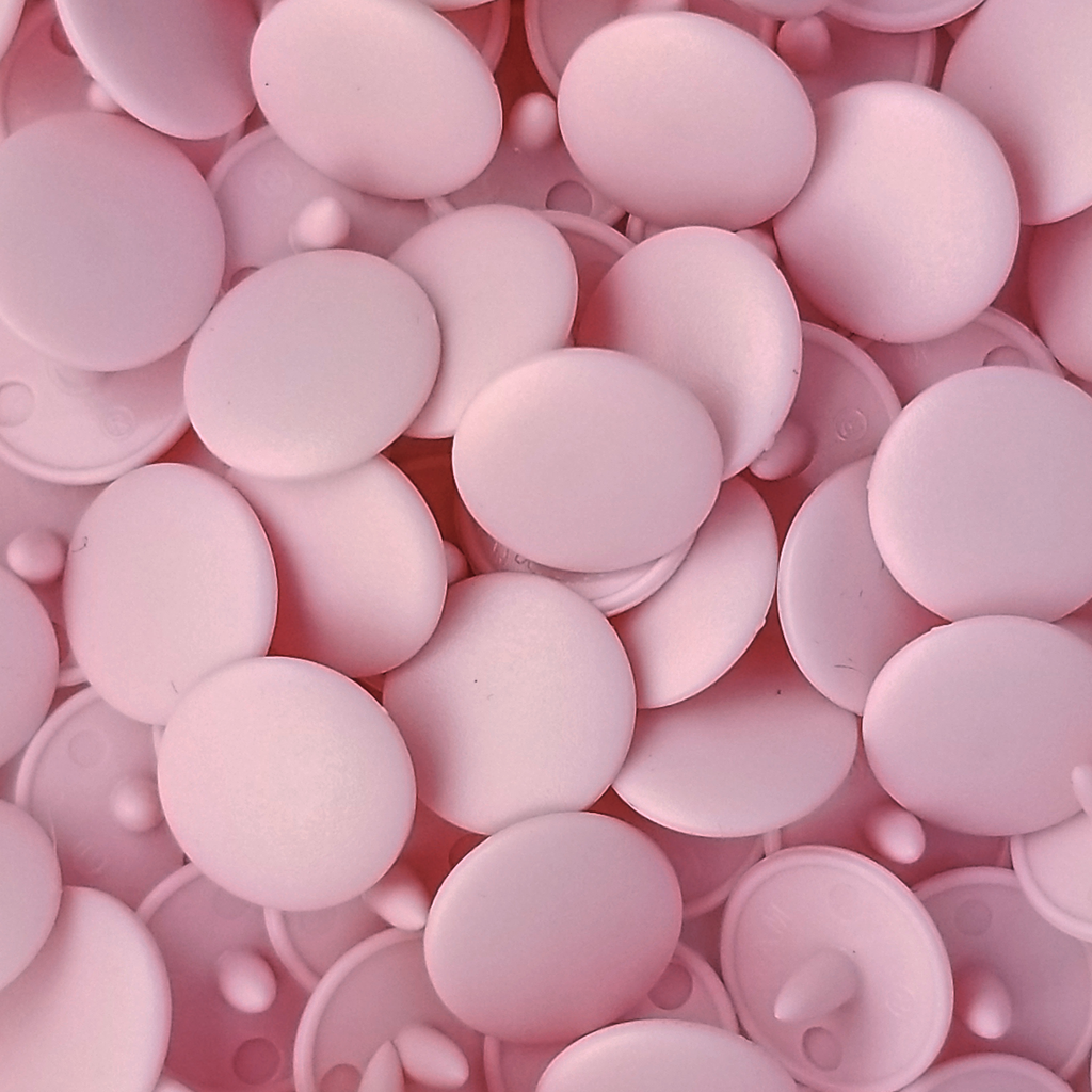 group of the pastel pink size 16 poly resin snaps for children's clothing sold at Heit's Wholesale bulks sewing supply company