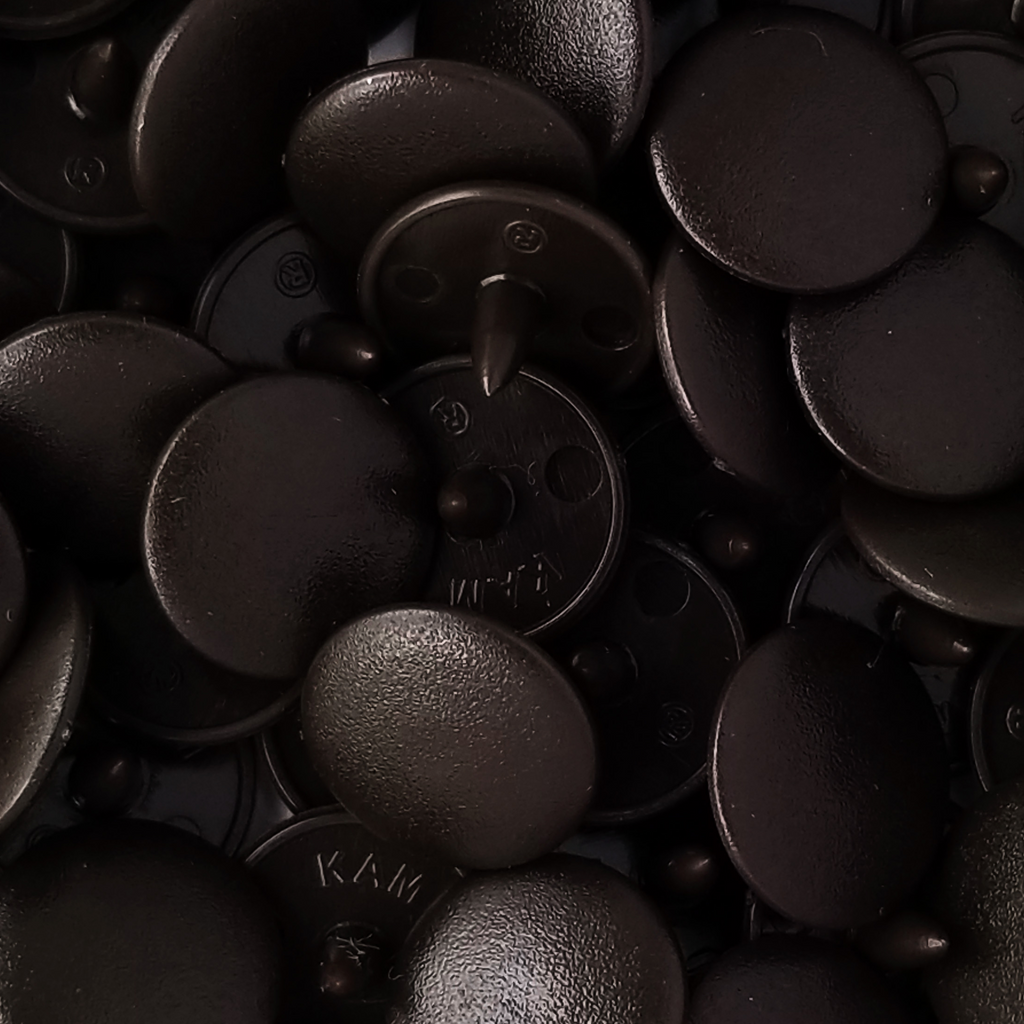 close up of the dark brown size 20 poly resin snaps with a matte finish from Heit's Wholesale bulk sewing supply company 