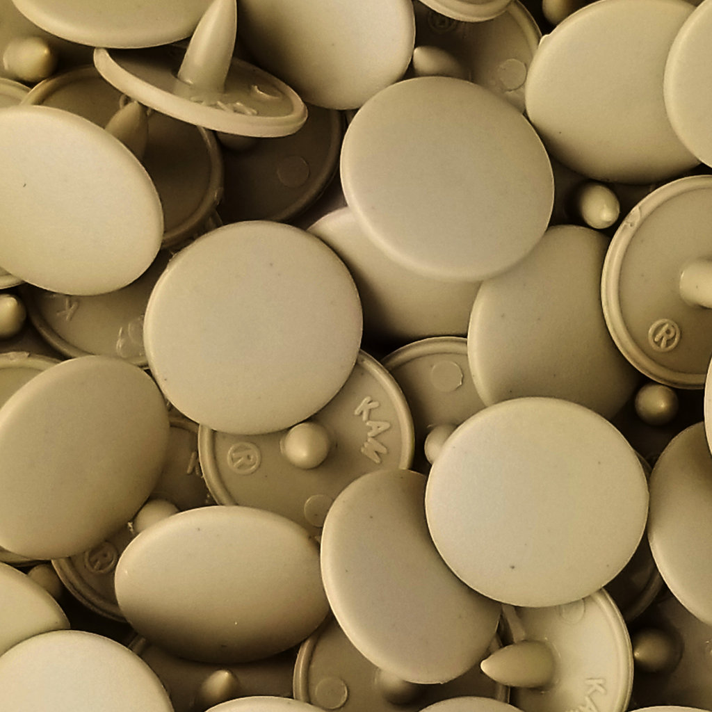 close up of the tan size 20 poly resin snaps with a matte finish from Heit's Wholesale bulk sewing supply company 